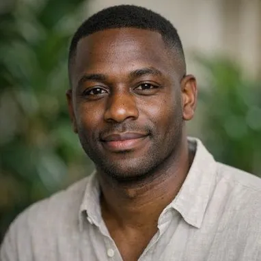Man in late 30s, short fade, dark eyes, relaxed open-collar shirt